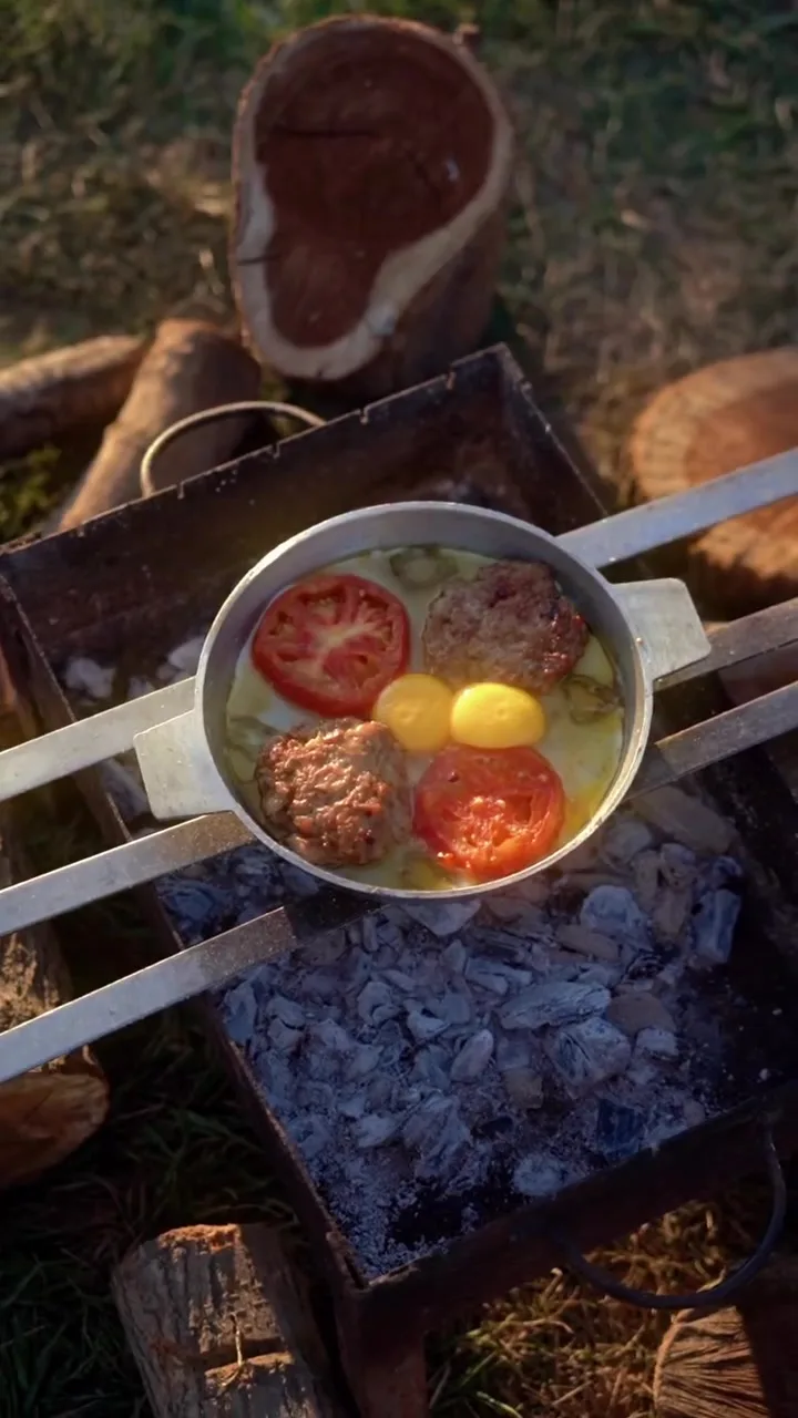 Közlər üzərində pomidor, kotlet və yumurta ilə tava